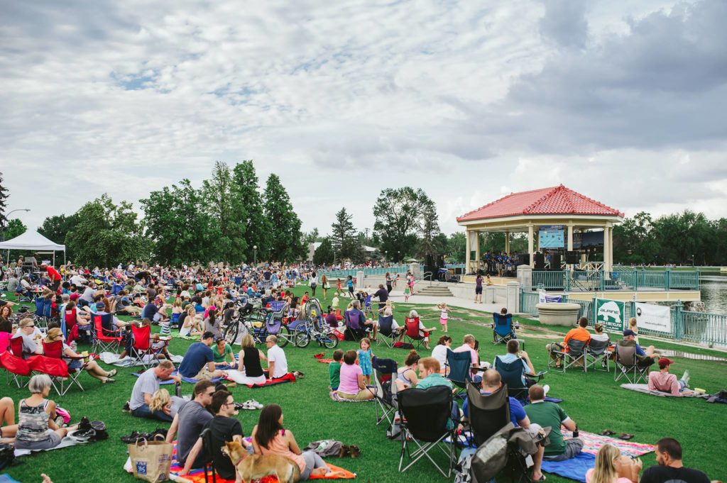 People outside on grass, trees, chairs