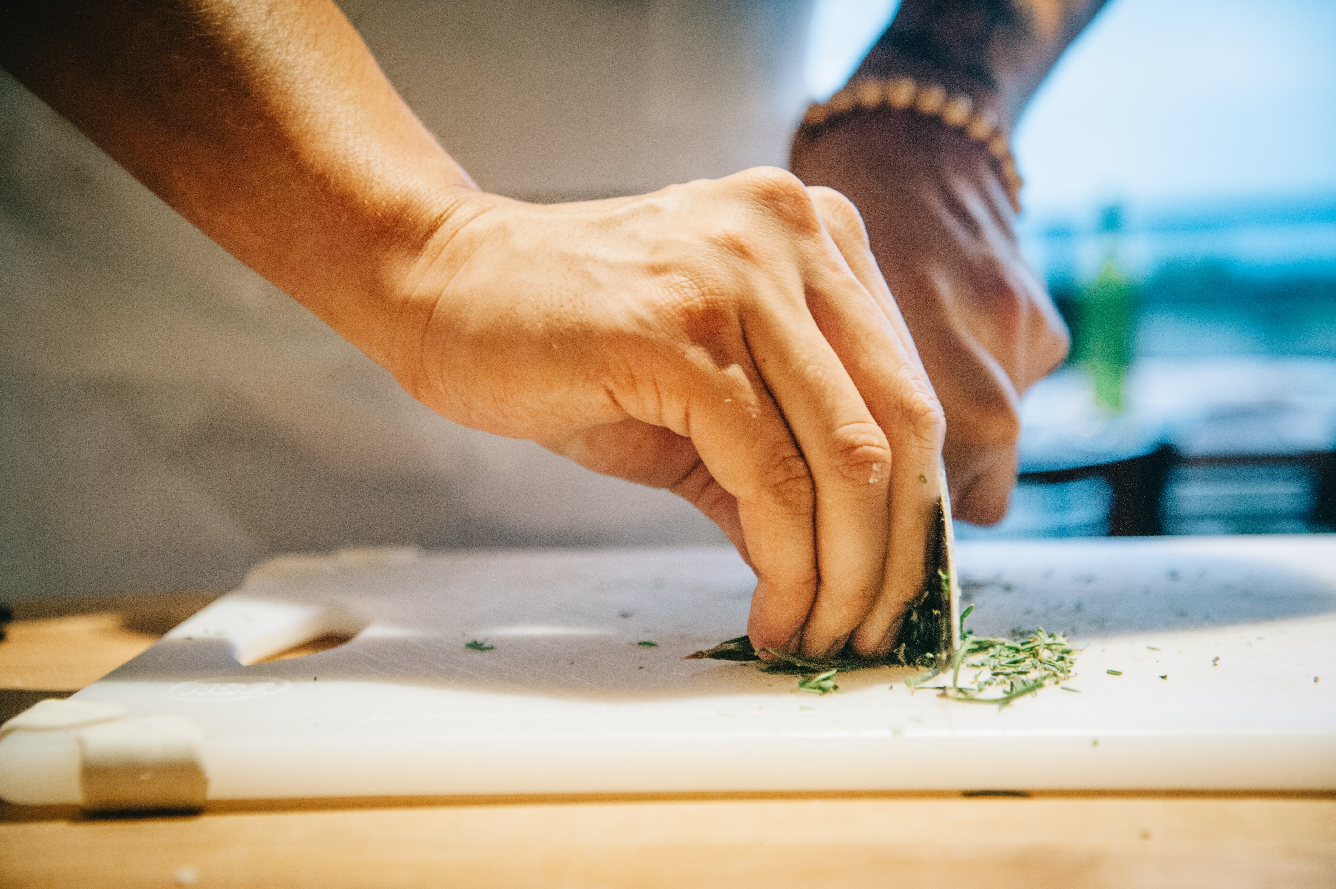 Finely chopping rosemary for a pizza topping. 