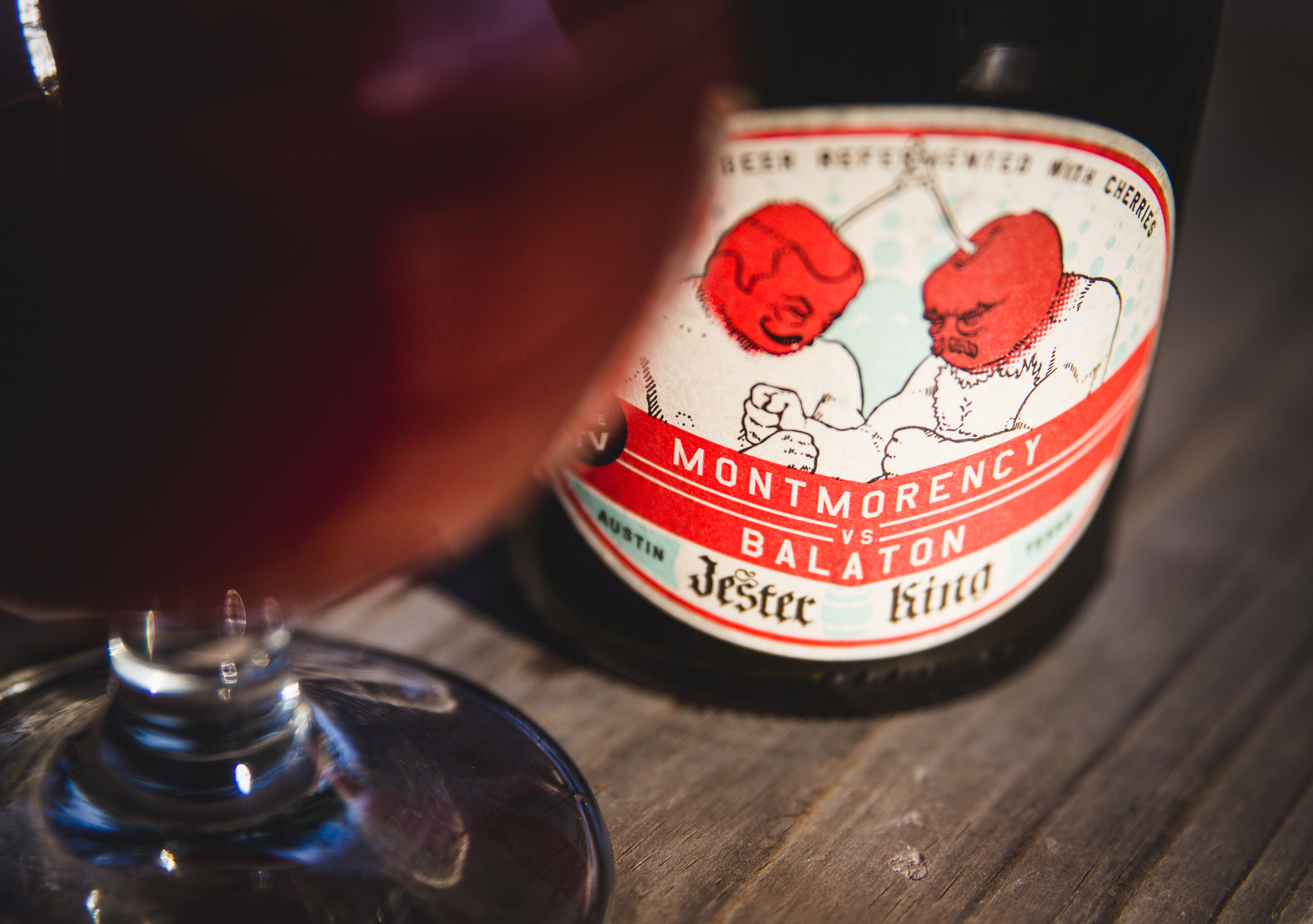 A glass and label art for Jester King's barrel-aged sour cherry ale Montmorency vs. Balaton. Photo courtesy of Jeffrey Stuffings of Jester King Brewery.