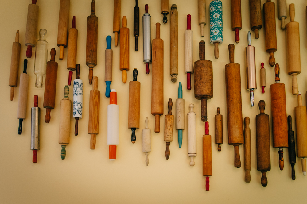Weathered and loved rolling pins hang from the wall in decorative way.