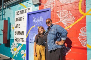 From left to right, artists Valerie Rose and Chloe Duplessis stand in front of their newest mural.