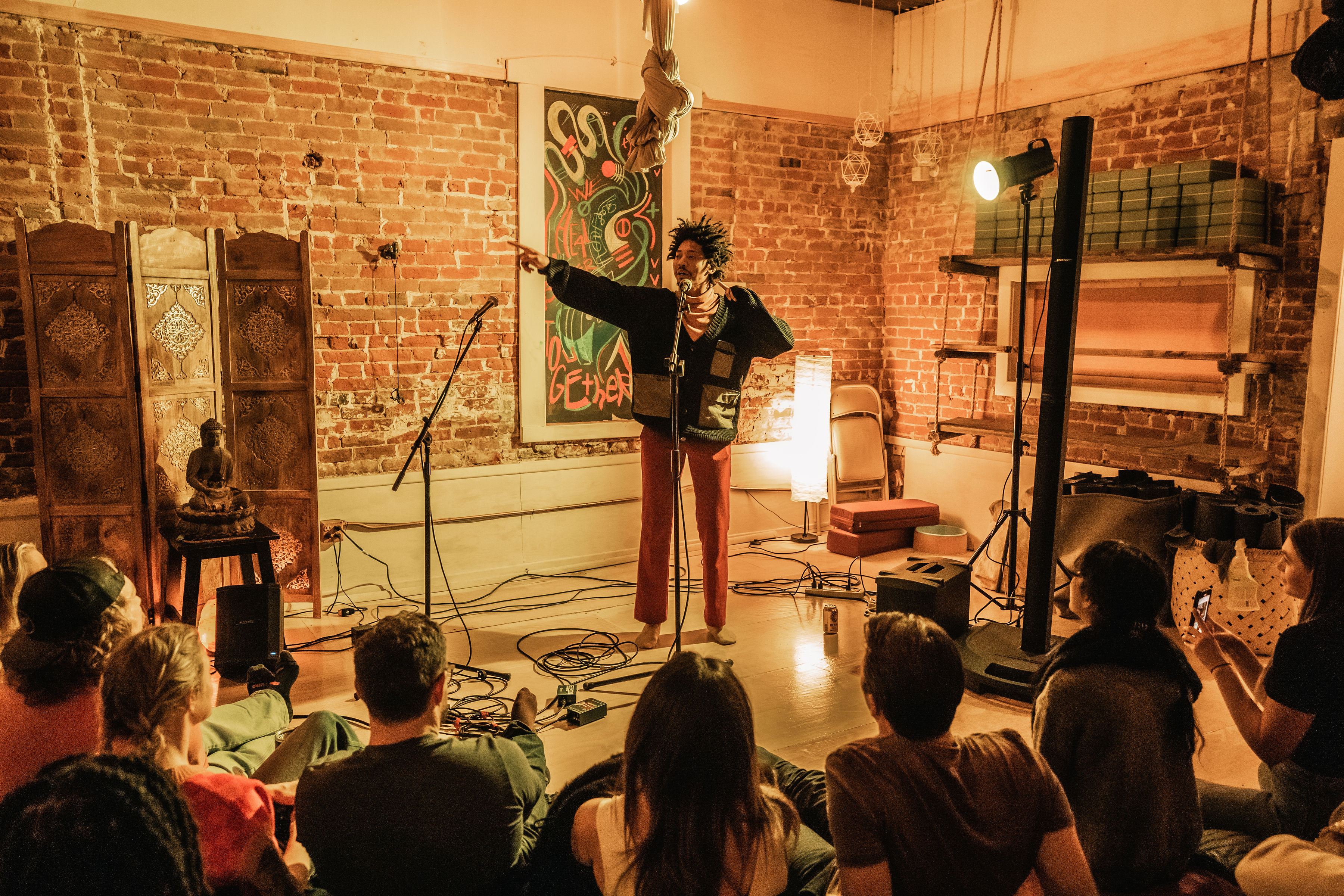 SoFar Sounds show in Denver featuring Hakeem Furious. Small room lit with orange light.
