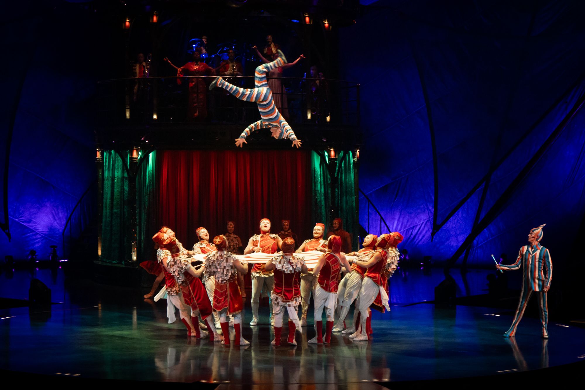 Group holding trampoline, person in the air, Cirque du Soleil: Kooza Returns to Denver
