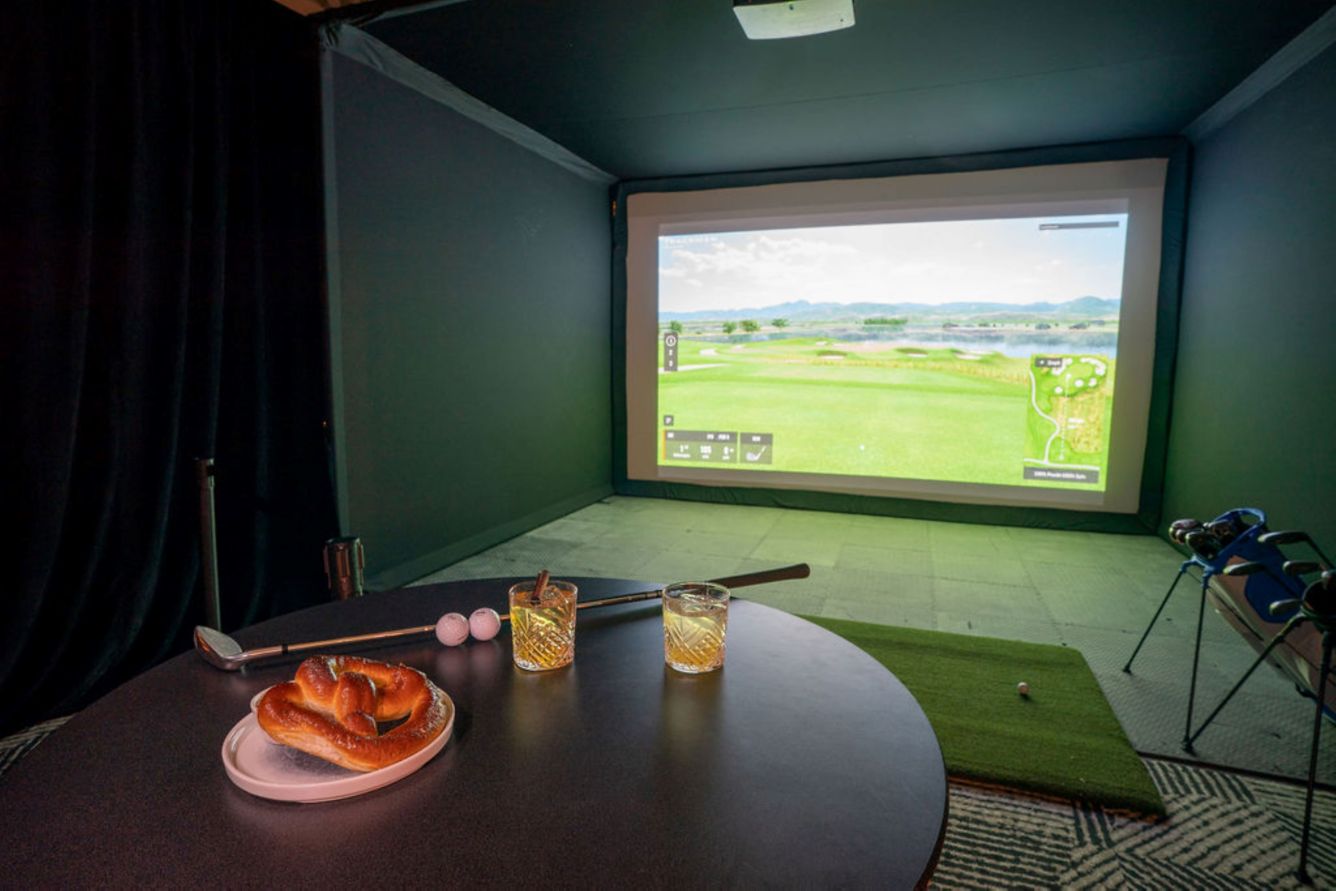 large screen displaying golf, cups and clubs on table