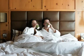 Couple in bed drinking